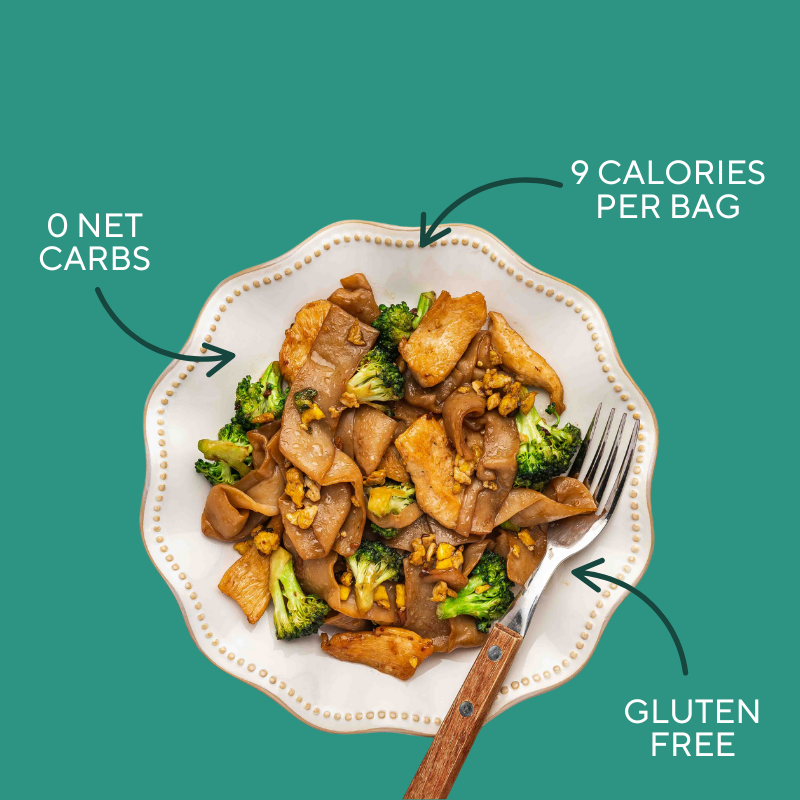 Plate of Pad See Ew with It' Skinny Pappardelle with text indicating 0 net carbs, 9 calories per bag, and gluten-free on a green background.