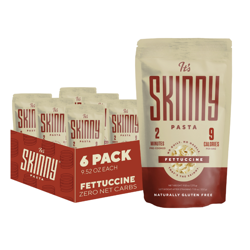 A single package of It's Skinny Fettuccine Pasta is displayed in front of a 6 pack of It's Skinny.