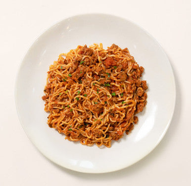 An overhead image of a bowl of tomato basil pasta prepared with low-carb It's Skinny Spaghetti pasta alternative.