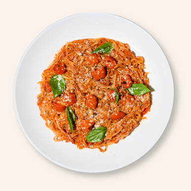 An overhead image of a bowl of tomato basil pasta made with It's Skinny Organic Spaghetti.